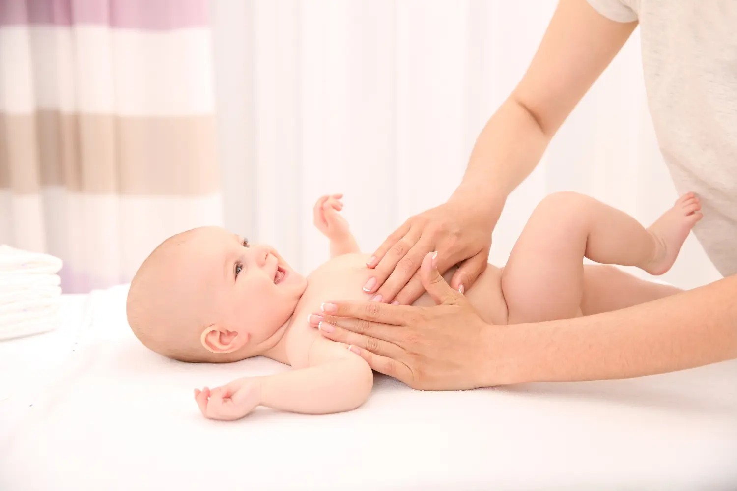 Mutter cremt ihr Baby nach dem Baden im Zimmer ein