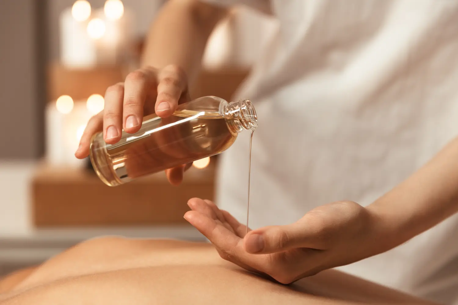 Nahaufnahme einer Masseurin, die Massageöl einfüllt