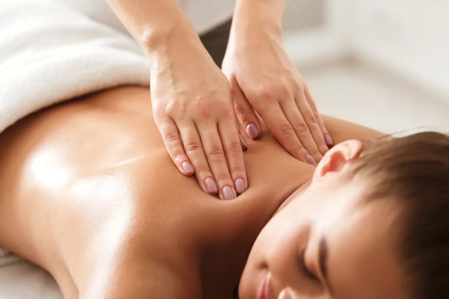 Junge Frau genießt therapeutische Nackenmassage im Spa