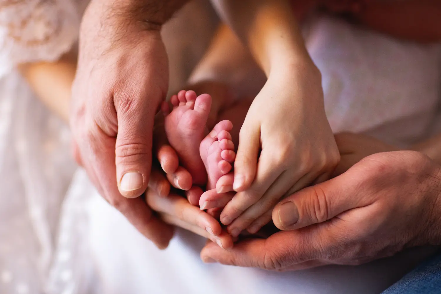 Familie mit Baby hält zu Hause die Hände zusammen